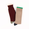 Two pairs of socks, one wine and one beige with green trim, on a white background.