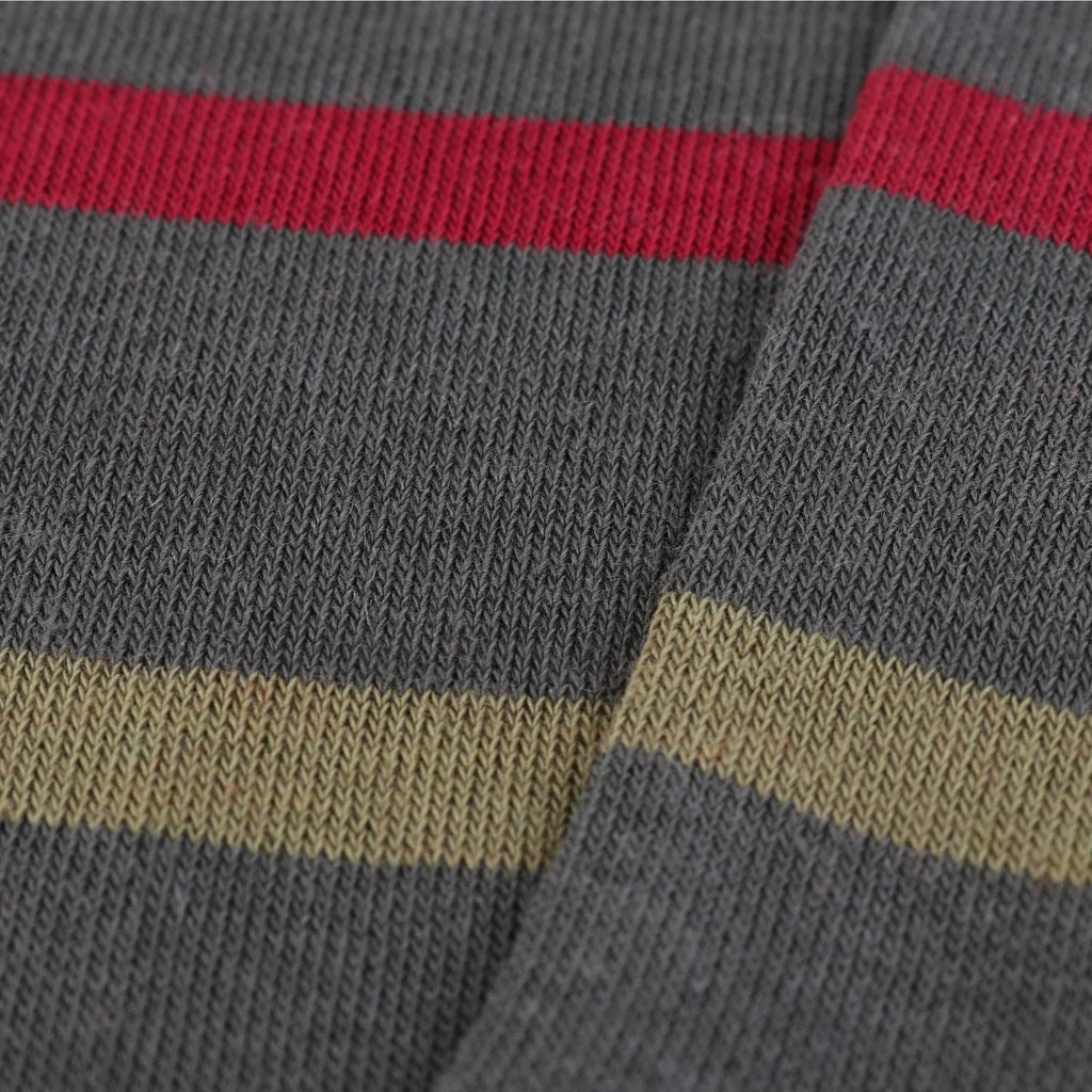Close-up of a GREEN SOCKS with red AND BEIGE stripes.