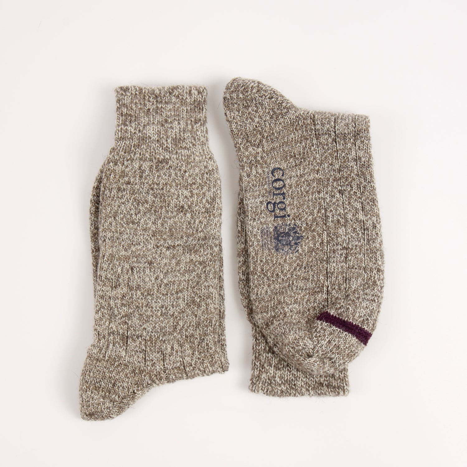 Pair of beige socks with 'corgi' branding on a white background