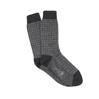 A pair of men's formal houndstooth merino wool socks in grey, showing the pattern and texture.