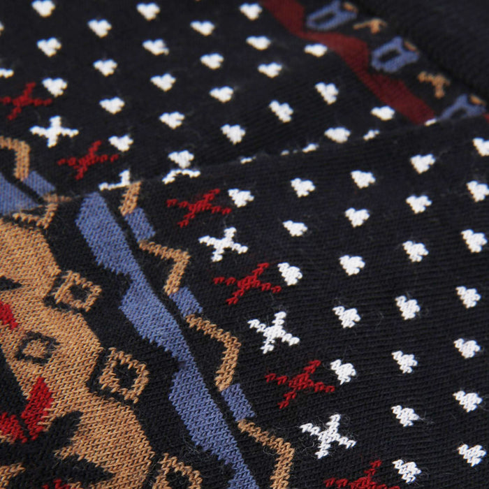 Close-up of a patterned sock with geometric designs and small white shapes.