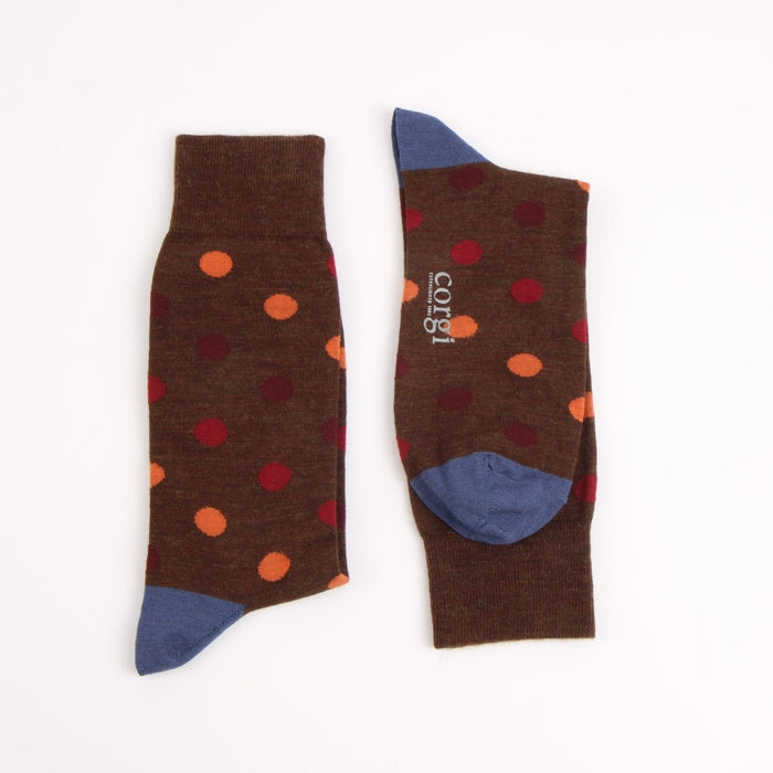 Pair of brown socks with colourful polka dots , contrast blue heel and toe photographed on a white background 