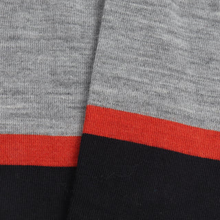 Close-up of the sock fabric with silver, orange and wine stripes.