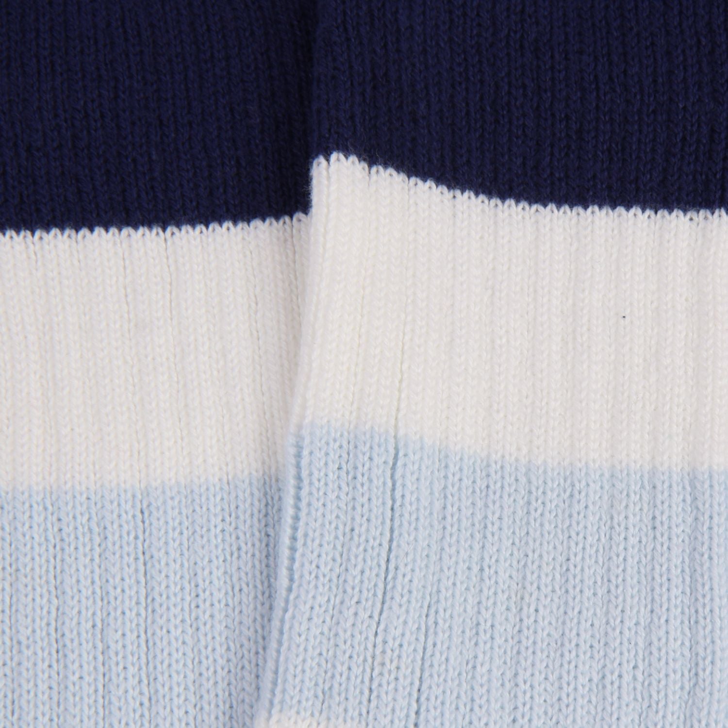 Close-up of a sock with navy, white, and light blue horizontal stripes.