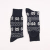 Two navy blue socks with white snowflake patterns on a white background