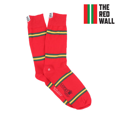 A pair of red, yellow, and green striped socks with the text 'Red Wall' and a Welsh flag color stripe pattern. The socks have a logo on the ankle area and a heel tab.