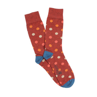 Rust/red mix socks with multicoloured polka dots photographed on a white background