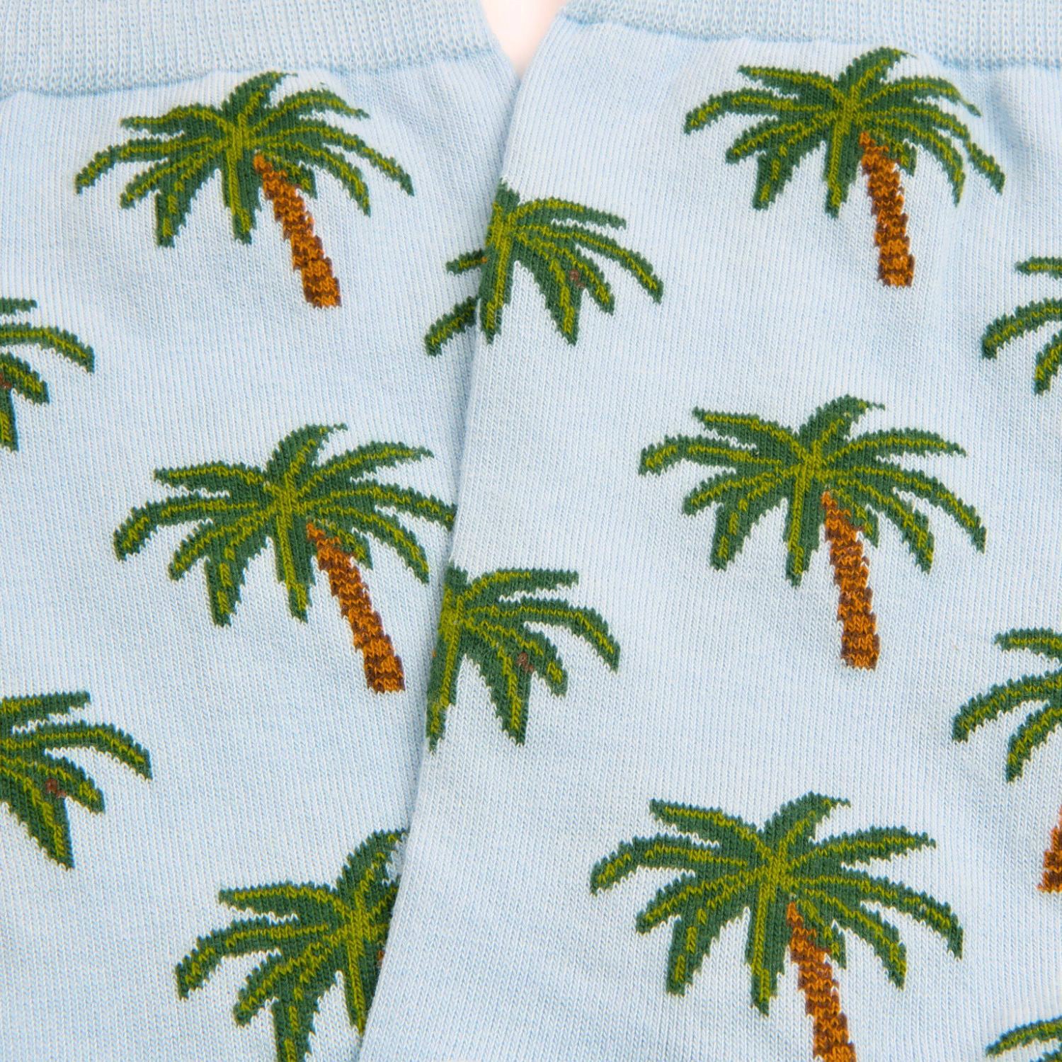 Light blue socks with green palm tree pattern