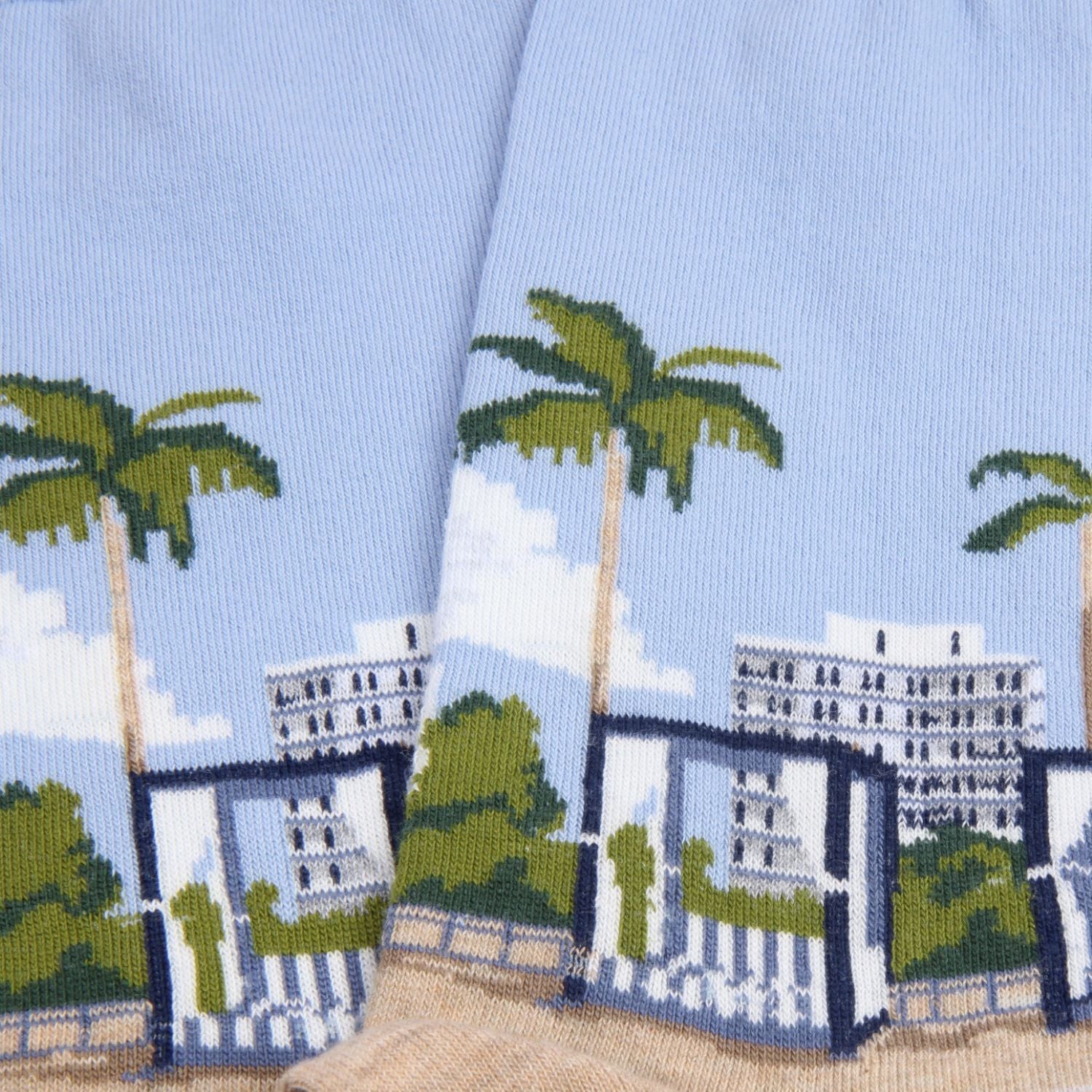 Socks with a design of palm trees and buildings on a blue background