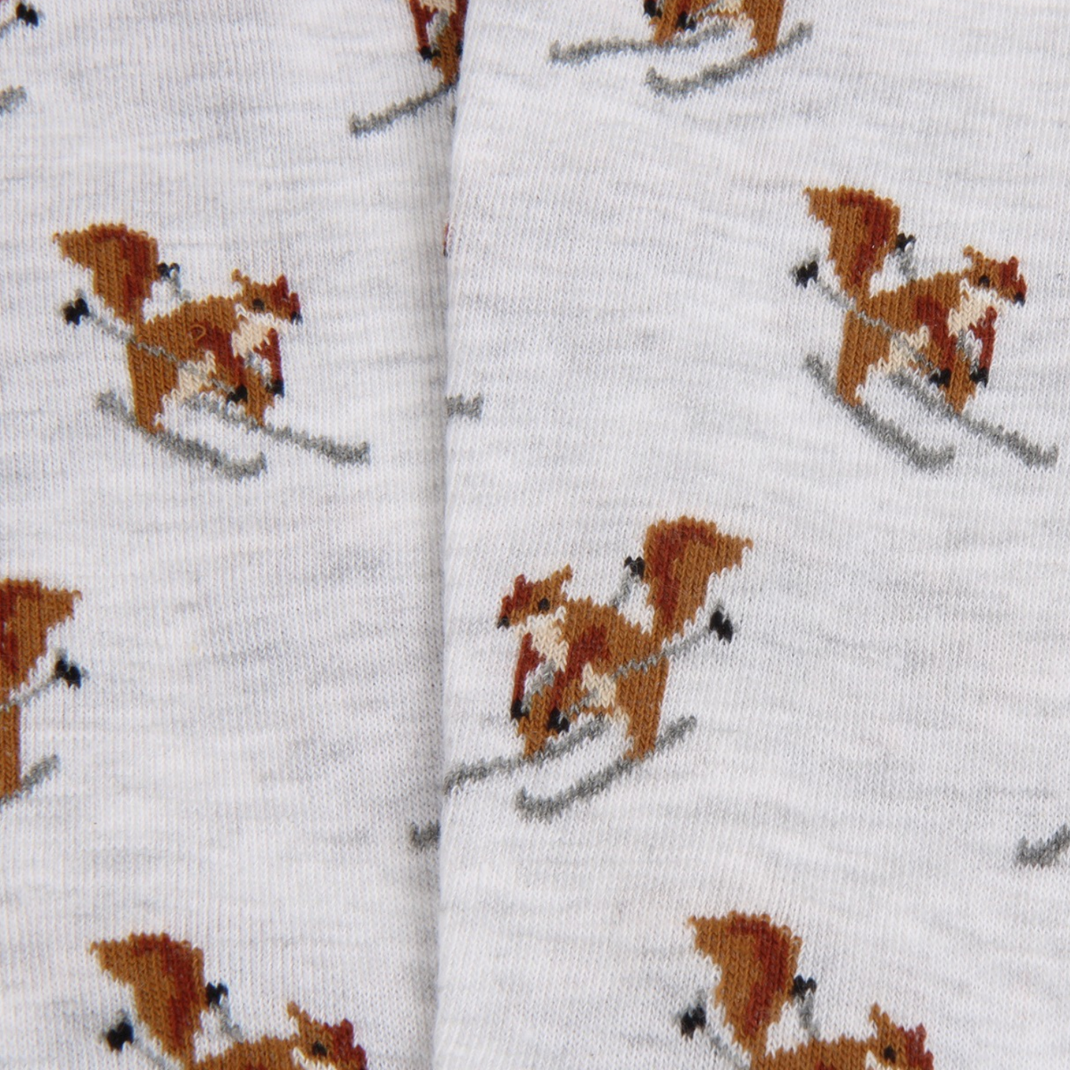 Close-up of white knit fabric with an allover pattern of brown and white squirrels skiing.