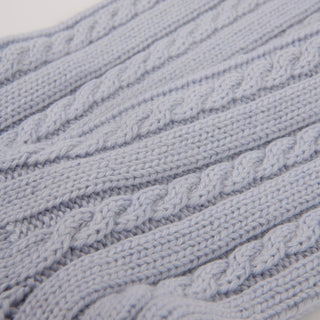 Close-up of a textured blue fabric with cable knit pattern

