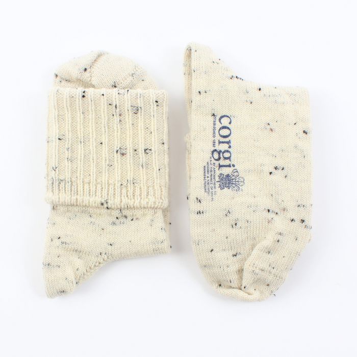 Pair of cream socks with speckled pattern on a white background, featuring the Corgi brand.