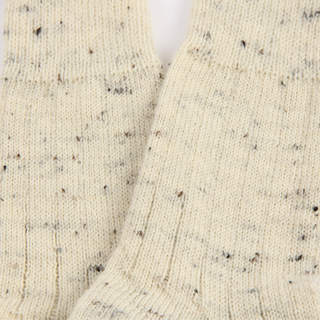 Close-up of a textured beige fabric with black specks