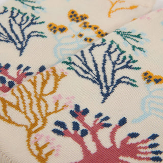 Close-up of a fabric with colorful coral reef pattern on a beige background
