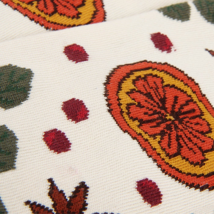 Close-up of a textile with floral patterns and red dots on a white background