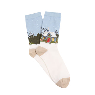 Sock with a winter scene of a house and trees on a light blue background