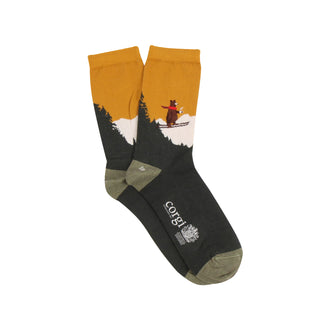 Socks with a design of a bear skiing through trees on a mustard background, brand 'Corgi' visible.