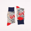 Pair of socks with floral pattern and red accents on a white background