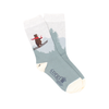A pair of kids' socks with a skiing bear design, placed against a Christmas-themed backdrop with holiday ornaments.