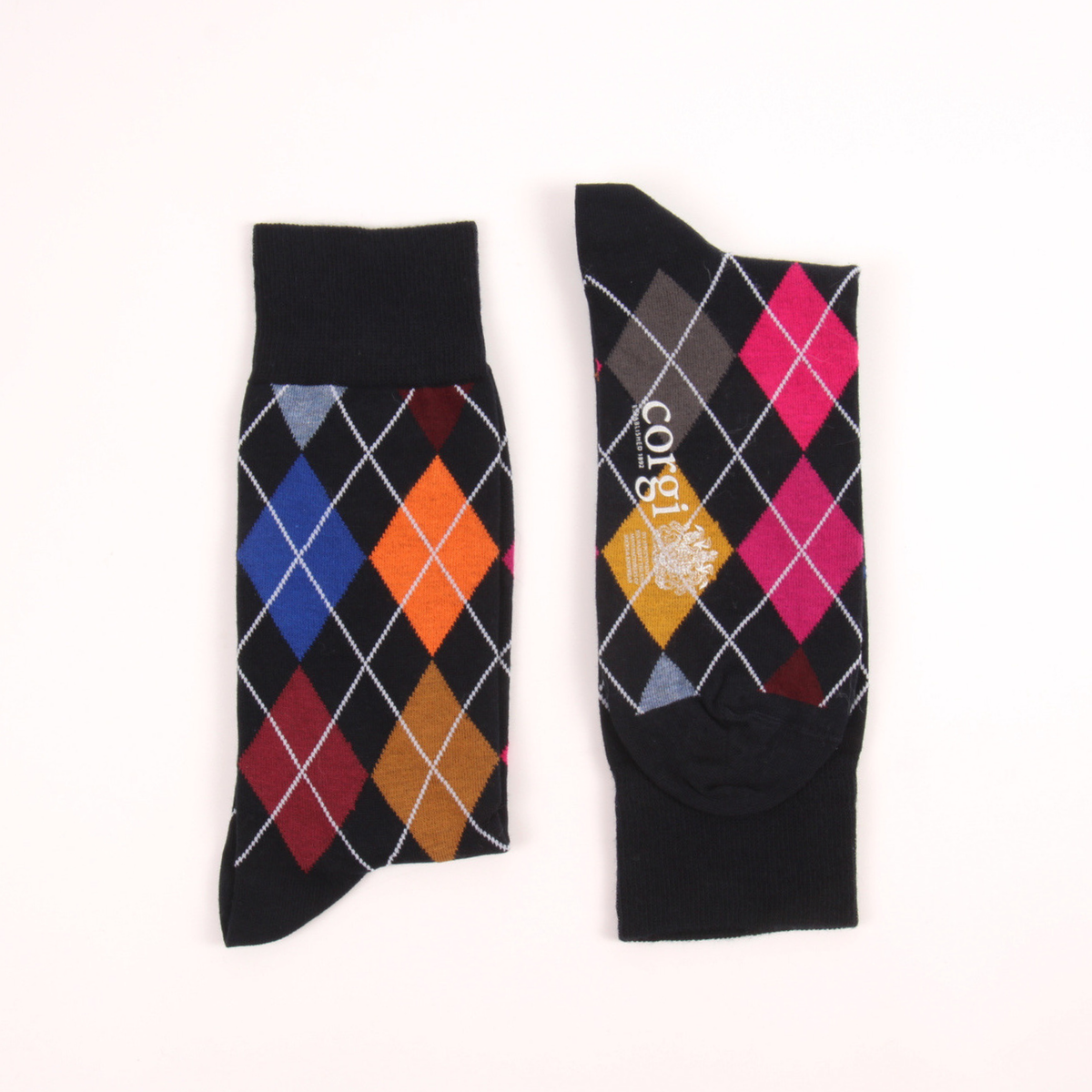 A pair of black crew socks with an argyle diamond pattern in blue, orange, red, yellow, and pink, displayed flat on a white background. One sock shows the patterned leg section with the brand name 'cot & gabi' printed vertically, and the other shows the solid black foot section.