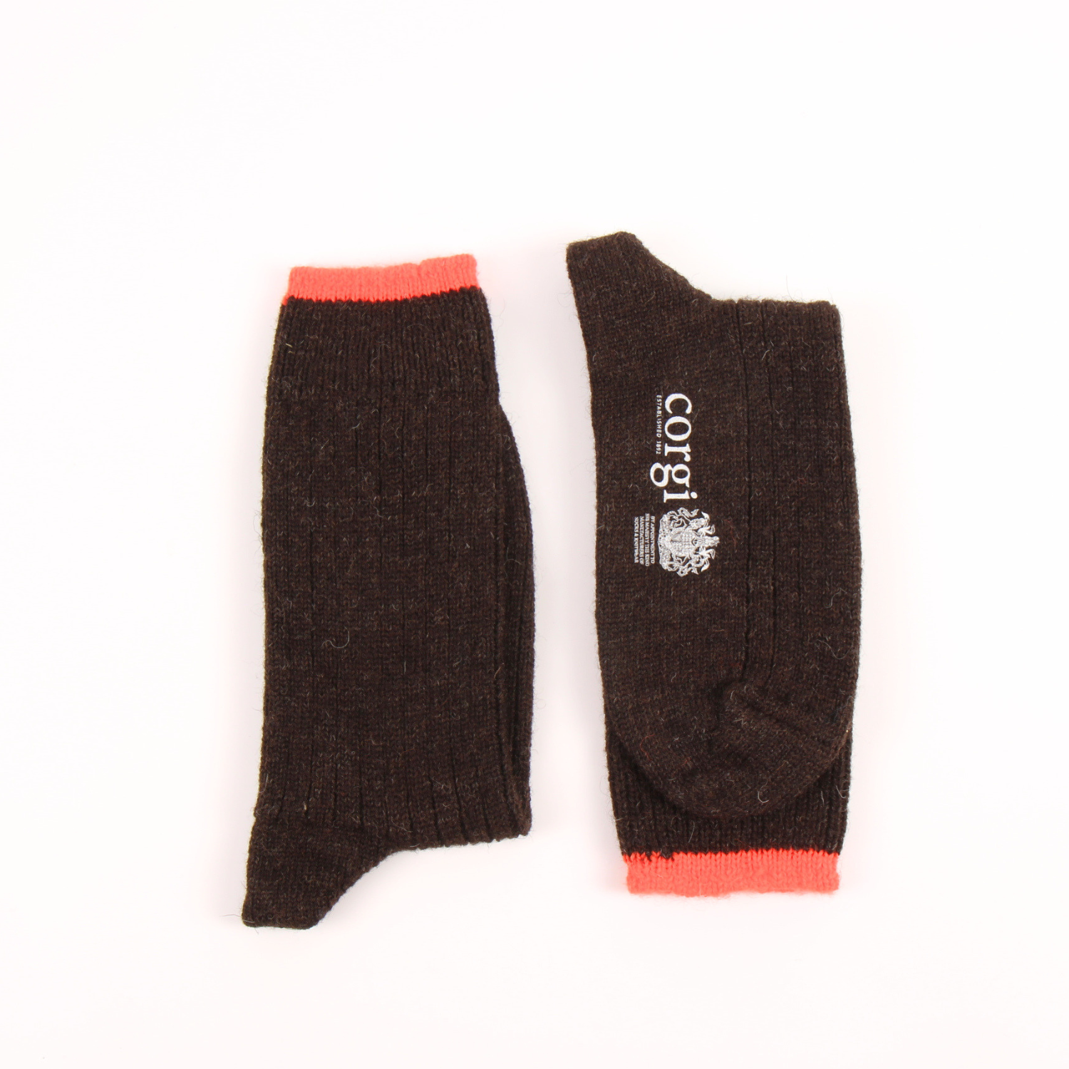 A pair of dark brown ribbed knit leg warmers with bright orange cuffs, shown flat on a white background. One leg warmer is displayed upright to show the ribbed texture and orange cuff, while the other is laid flat to show the interior side with a white printed 'corgi' logo.