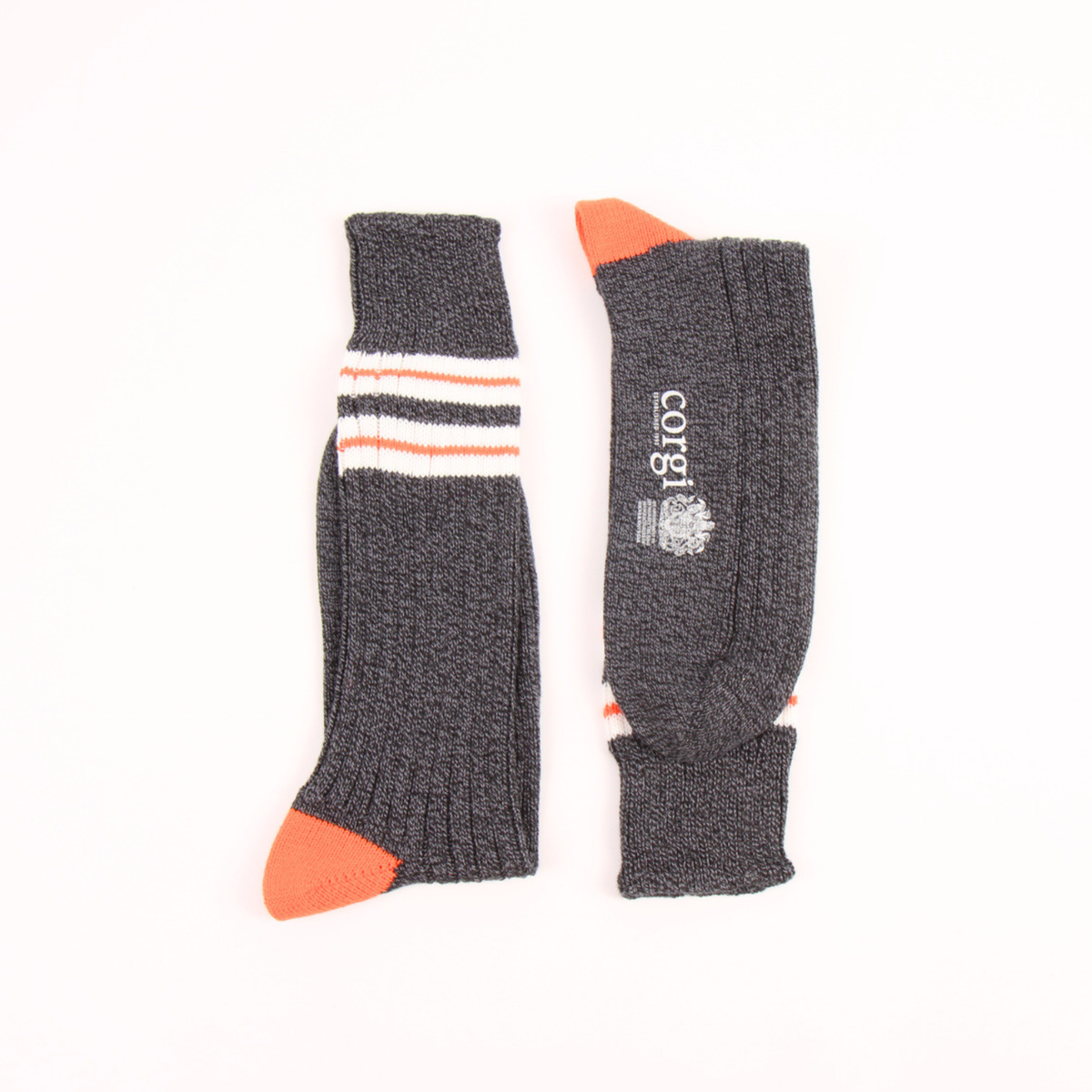 A pair of dark gray ribbed socks with orange and white stripes, shown flat on a white background. One sock displays the white 'corgi' brand name and logo.