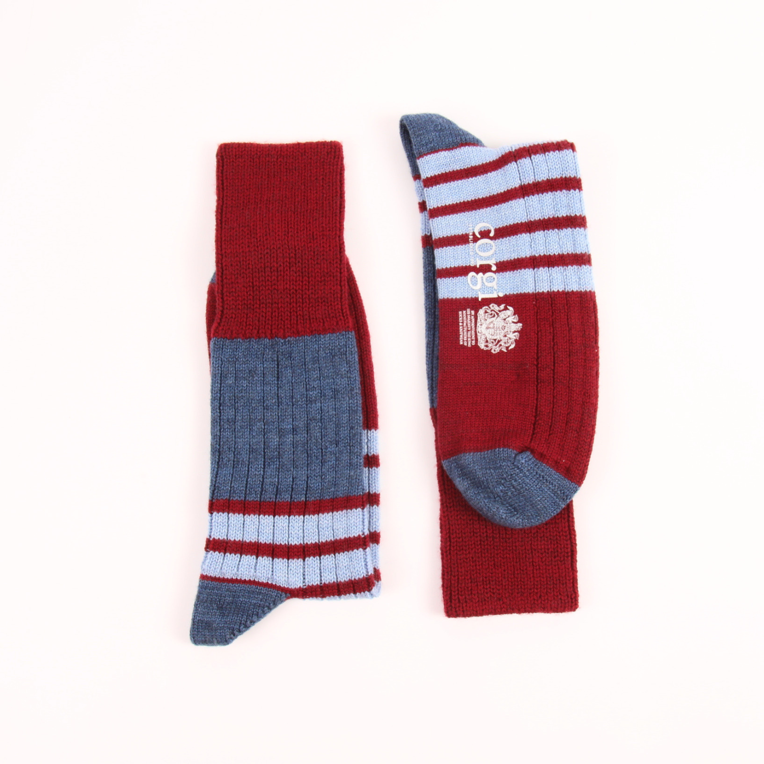 A pair of crew socks laid flat on a white background. One sock is shown upright, displaying a dark red cuff and lower leg, a heathered slate blue mid-calf section, and light blue and red stripes near the foot.