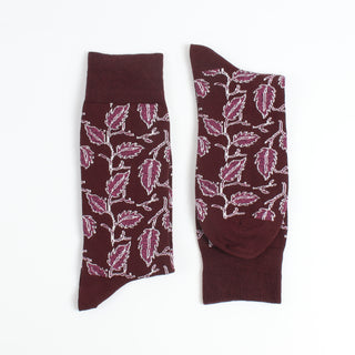 Pair of maroon socks with pink leaf pattern on a white background
