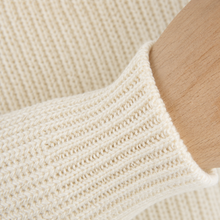 Close-up of a beige knitted sweater sleeve