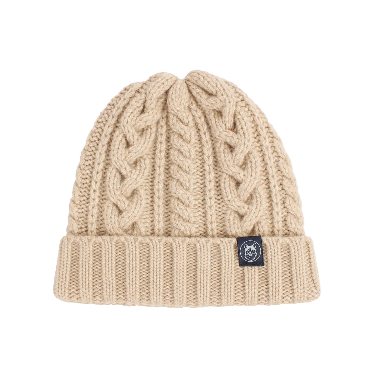 A beige cable-knit beanie hat with a folded cuff and a small black brand patch on the side, shown against a light gray background.