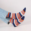 Colorful striped socks with blue jeans on a light gray background