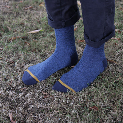 Blue socks with yellow trim worn on grass