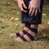 Person wearing striped socks outdoors on a grassy area