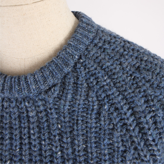 Close-up of a blue knitted sweater on a mannequin.