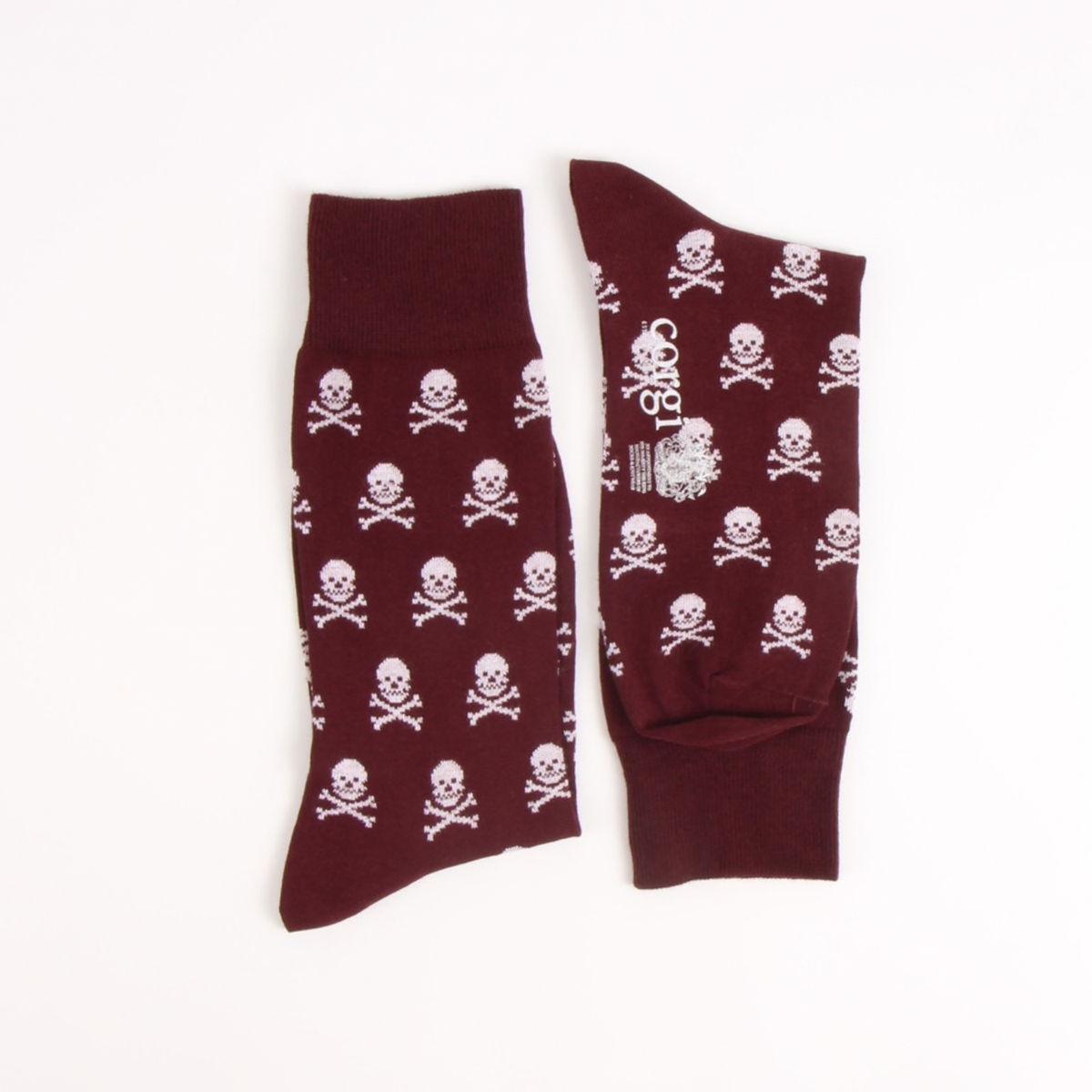 A pair of dark maroon crew socks with a repeating white skull and crossbones pattern, displayed flat against a plain white background.