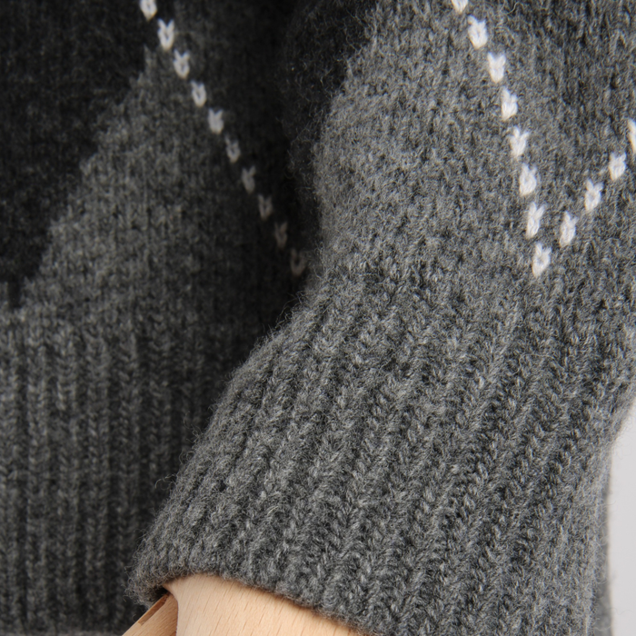 Close-up of a gray knitted sweater with a subtle pattern