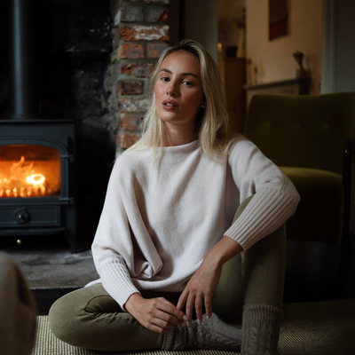 Woman sitting in a cozy living room with a fireplace