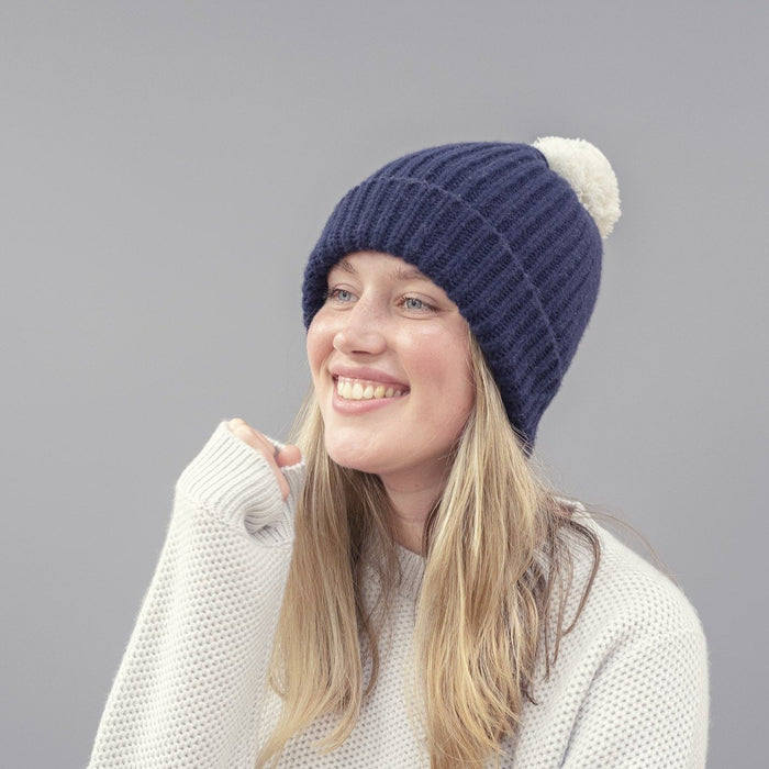 person wearing navy hat with white pom pom 