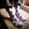 Person wearing pale grey socks with an all over black Labrador dog intarsia pattern