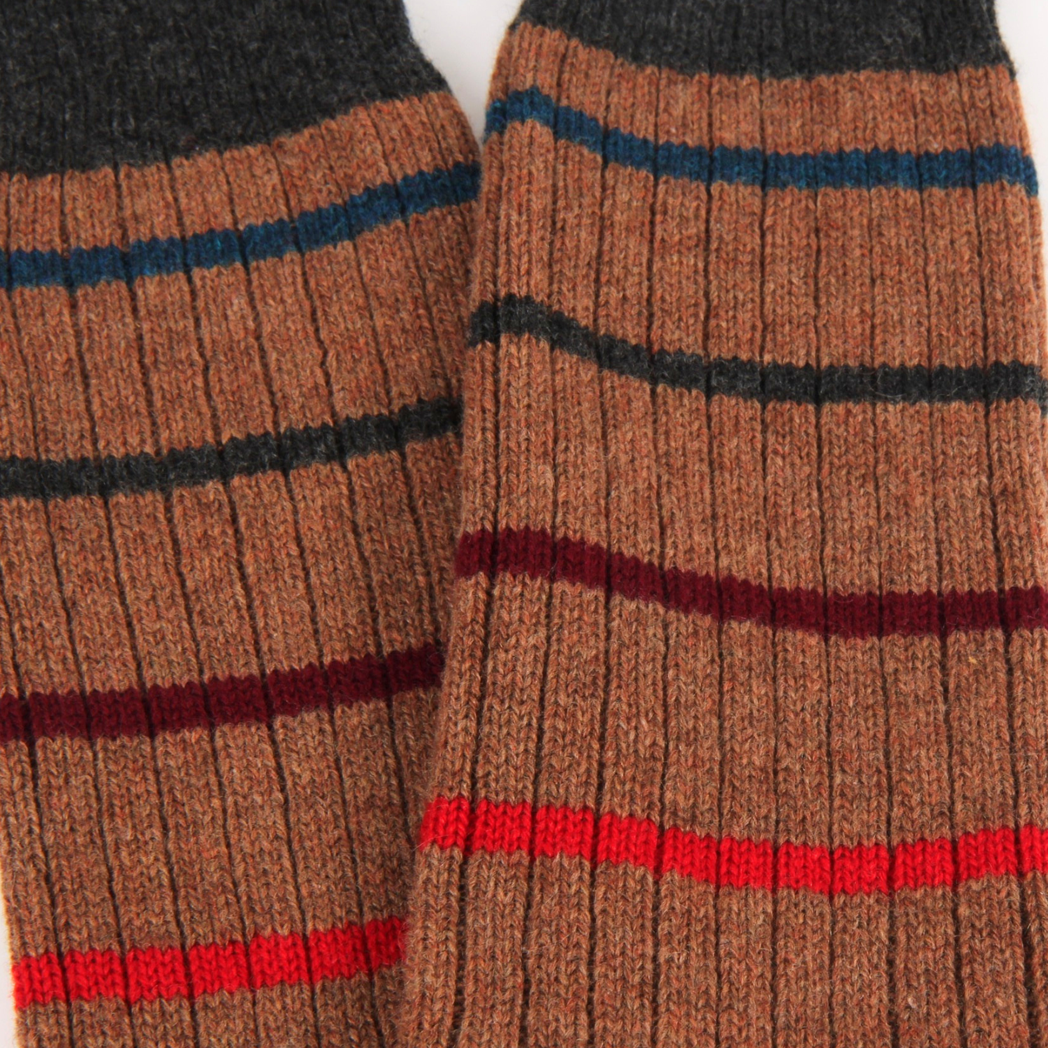 Close-up of brown striped socks with red, blue, and black stripes.