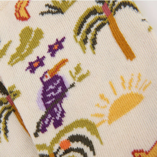 Close-up of a fabric with a tropical pattern featuring birds and palm trees.