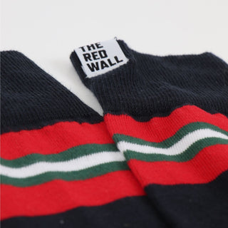 Socks with red, green, and white stripes and 'The Red Wall' label on a white background
