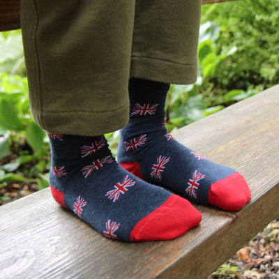 Child wearing socks with Union Jack design on a wooden bench outdoors