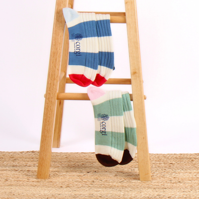 Colorful striped socks on a wooden stool with a white background