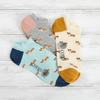 Four pairs of socks with corgi patterns on a wooden surface
