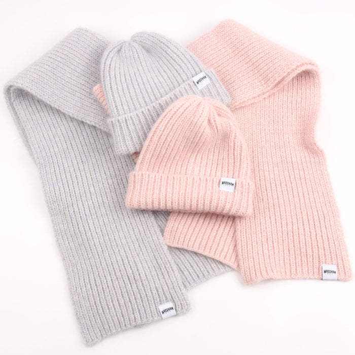 Two gray knit hats and two pink knit hats with a brand label on a white background