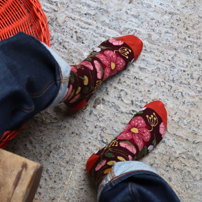 Person wearing floral patterned socks on a concrete floor