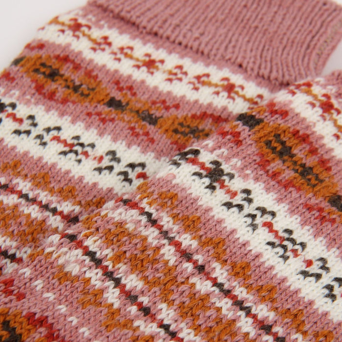 Close-up of a knitted sweater with a colorful pattern on a white background