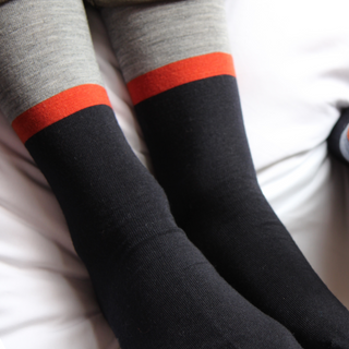 grey socks with orange stripes and navy foot on a white background