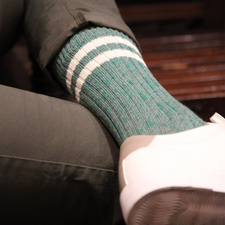 Person wearing green striped socks with a blurred background
